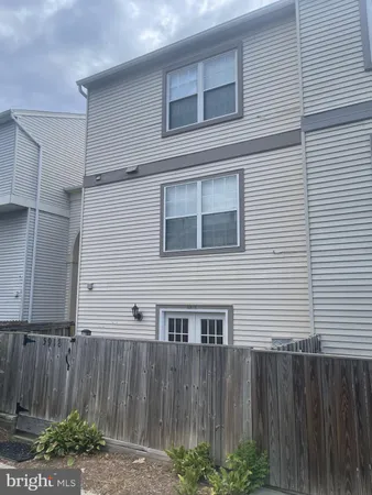 a view of a house with a backyard and wooden fence
