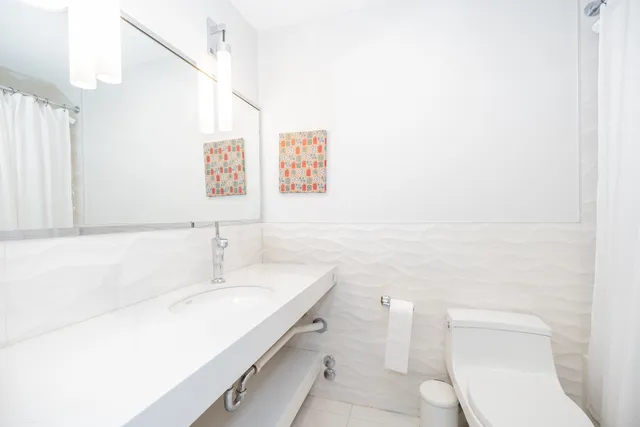 a white toilet sitting next to a white tub