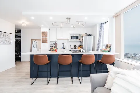 a view of kitchen with granite countertop dining room cabinets and stainless steel appliances