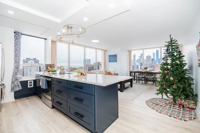 a kitchen with stainless steel appliances kitchen island granite countertop a table chairs sink and cabinets