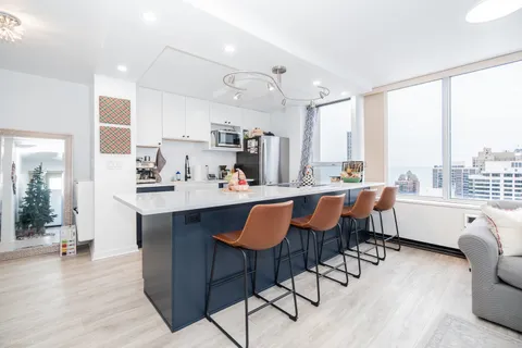 a kitchen with kitchen island a appliances dining table and chairs