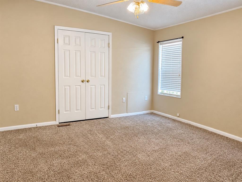 301 South Coppell Road, Unit 51 Coppell, TX 75019 - Photo 10 of 20 Carpeted room featuring a ceiling fan, a window with blinds, and paneled bifold closet doors