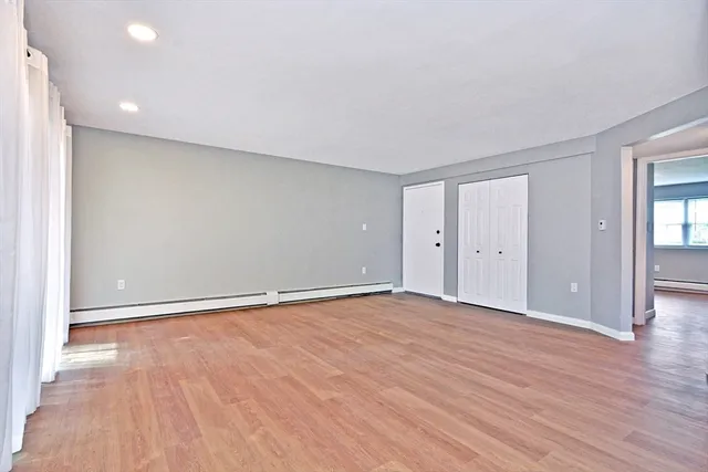 a view of an empty room with wooden floor