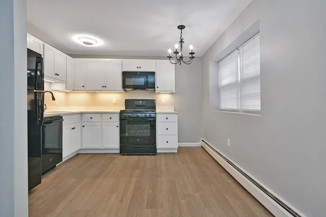 a open kitchen with a sink dishwasher a stove and a refrigerator with wooden floor