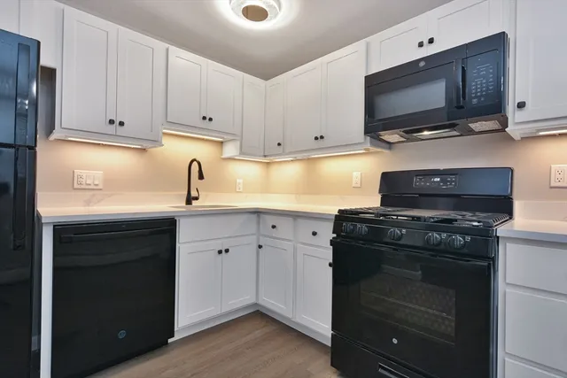 a kitchen with cabinets appliances and a sink