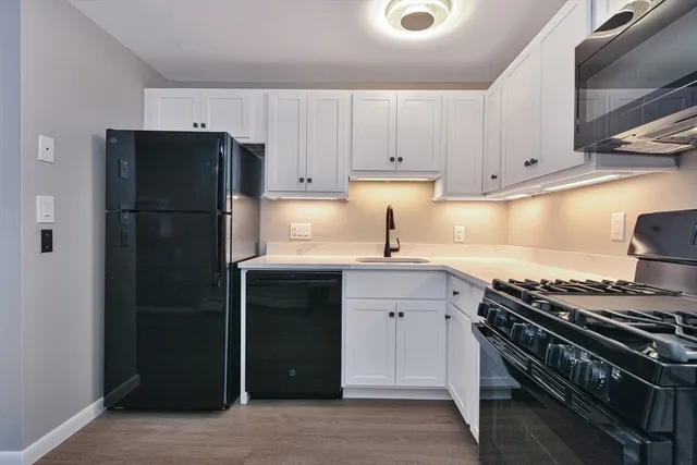 a kitchen with a refrigerator and a stove top oven