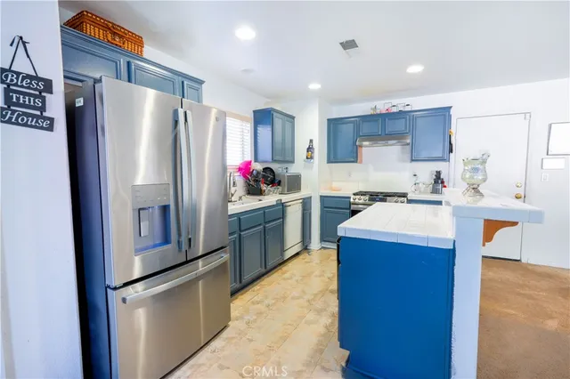 a kitchen with refrigerator cabinets and wooden floor