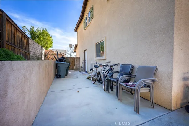 a view of a patio with chairs and potted plants