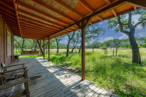 a view of a backyard with table and chairs under an umbrella with a small yard