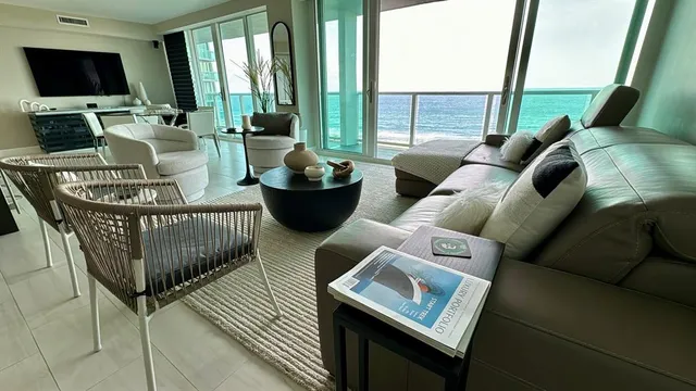 a living room with furniture and a floor to ceiling window