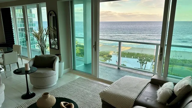 a living room with furniture and floor to ceiling windows
