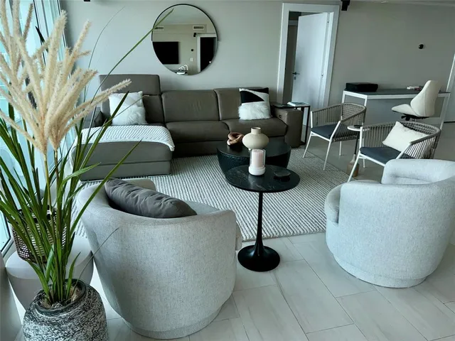 a living room with furniture and a floor to ceiling window