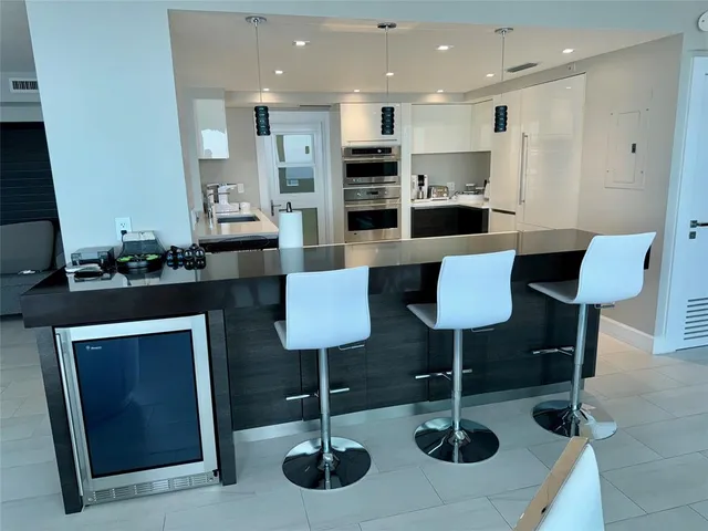 a kitchen with stainless steel appliances kitchen island granite countertop a table and chairs in it