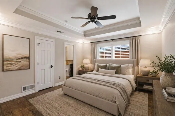 a bedroom with a large bed a chandelier and a window