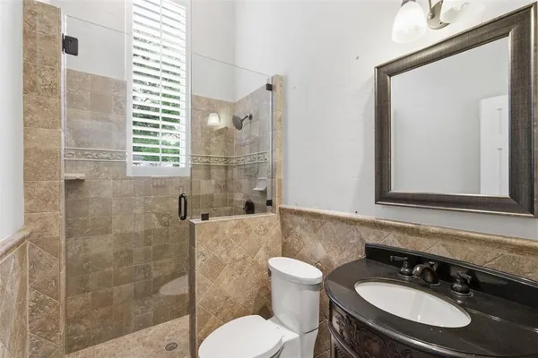 a bathroom with a sink toilet a mirror and shower
