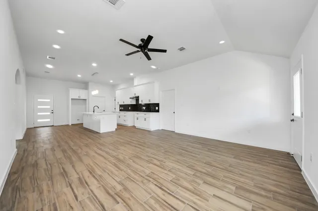 a view of empty room with wooden floor and windows