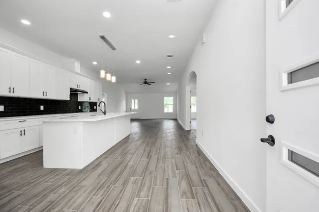 a view of kitchen with cabinets wooden floor and stainless steel appliances