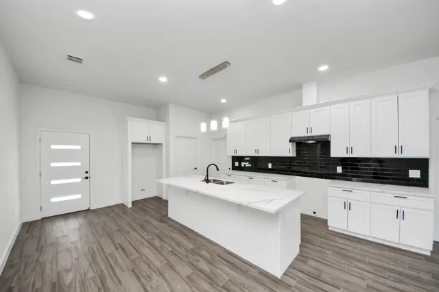 a kitchen with granite countertop a sink and cabinets