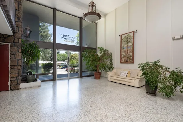 a living room with furniture and potted plants