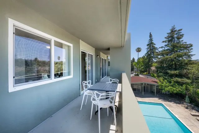 a patio with table and chairs and potted plants