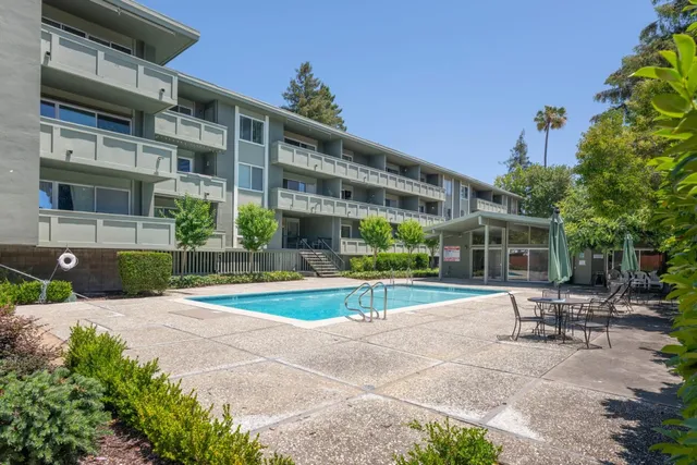 a view of a patio with a table and chairs under an umbrella