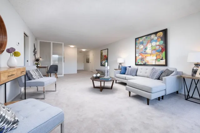 a living room with furniture and a painting on the wall