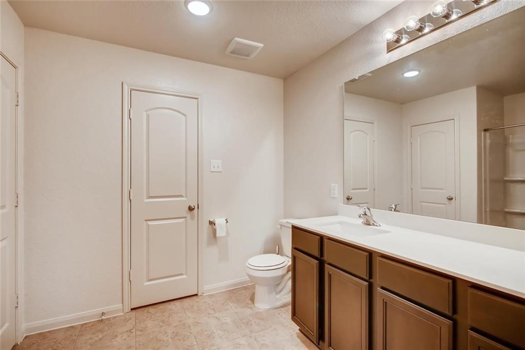20029 Grover Cleveland Way Manor, TX 78653 - Photo 5 of 8 a spacious bathroom with a toilet a sink a mirror and a shower
