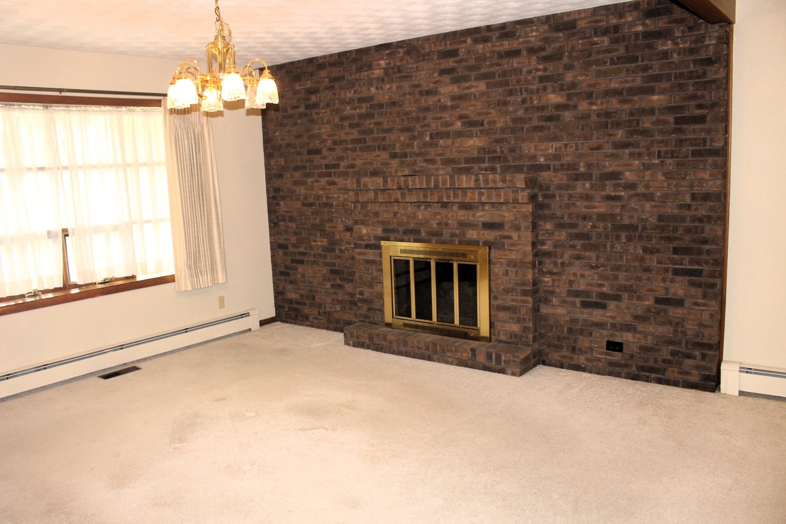 55 Hillcrest Drive Clinton, IL 61727 - Photo 5 of 22 a view of an empty room with a fireplace and a window