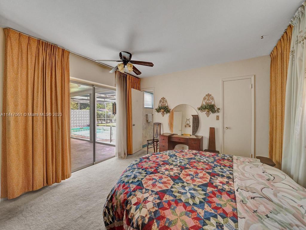 5525 Jackson Street Hollywood, FL 33021 - Photo 17 of 91 a bedroom with a large bed and a chandelier