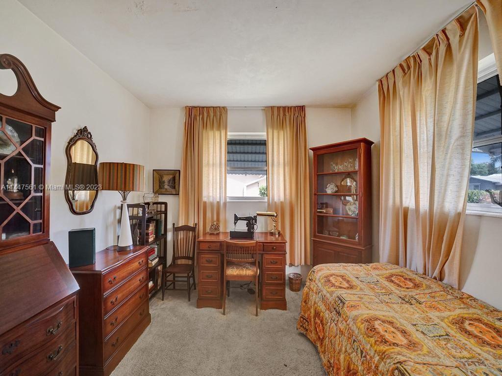5525 Jackson Street Hollywood, FL 33021 - Photo 20 of 91 a bedroom with a bed next to a window with chair and dresser