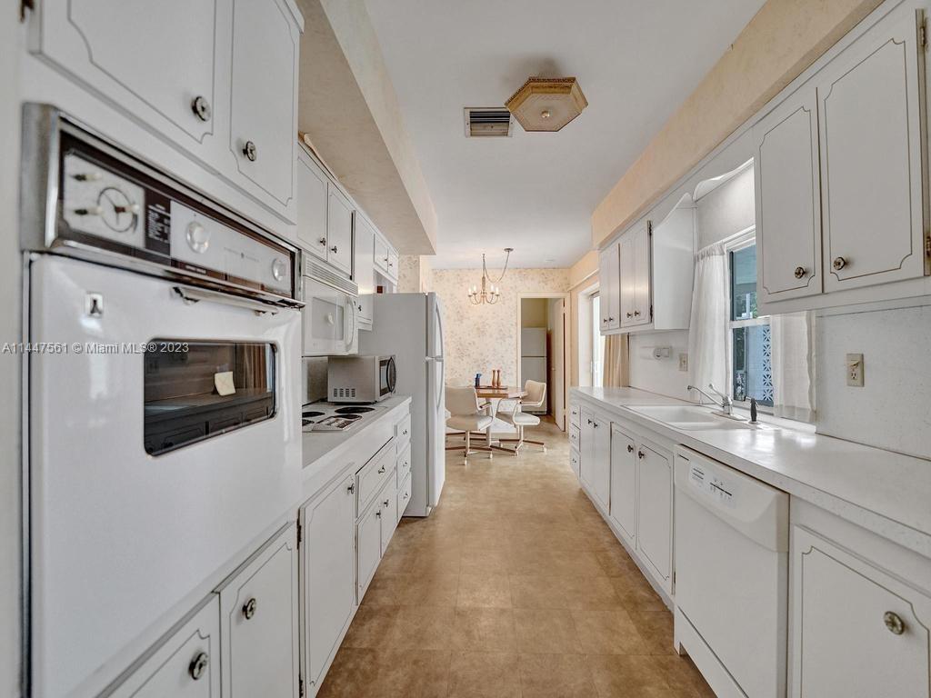 5525 Jackson Street Hollywood, FL 33021 - Photo 24 of 91 a large kitchen with stainless steel appliances a stove sink and cabinets