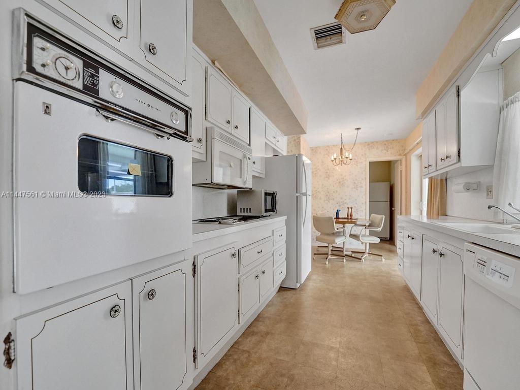 5525 Jackson Street Hollywood, FL 33021 - Photo 25 of 91 a large white kitchen with stainless steel appliances