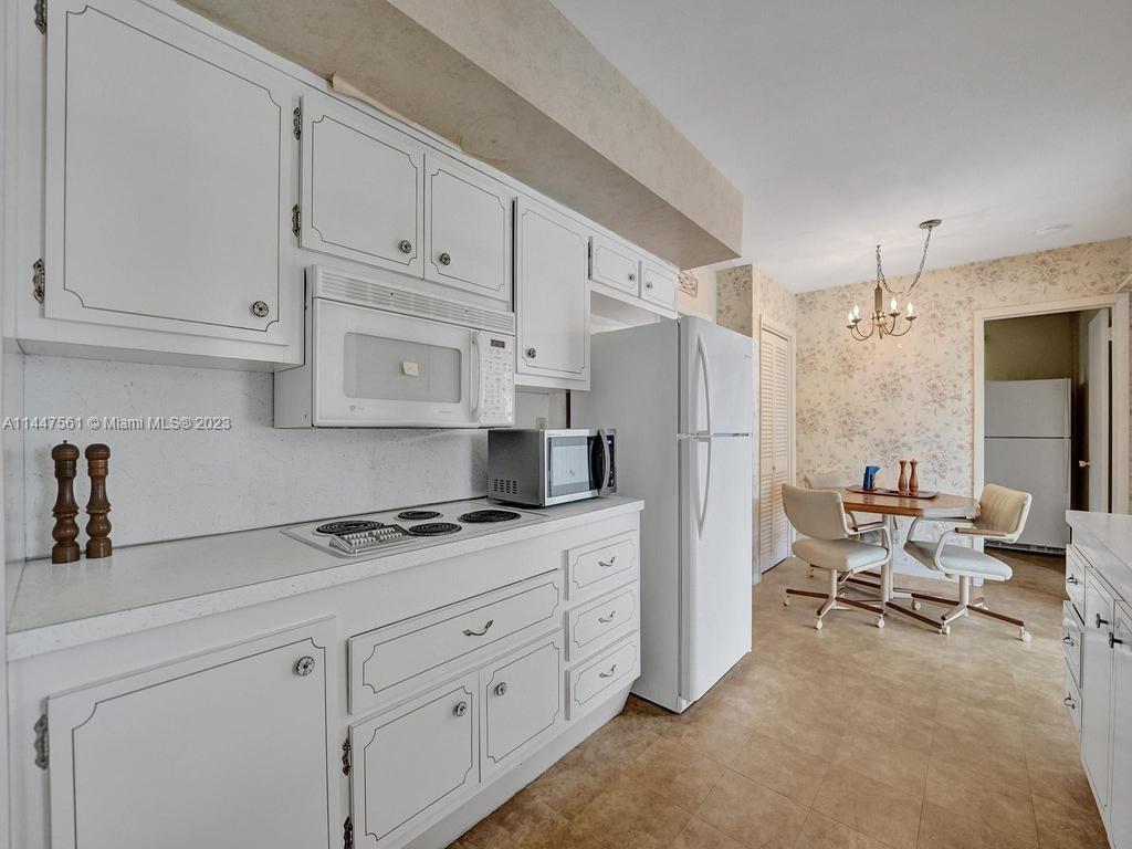 5525 Jackson Street Hollywood, FL 33021 - Photo 27 of 91 a kitchen with white cabinets and refrigerator