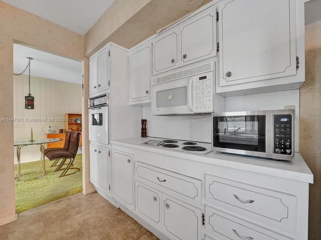 5525 Jackson Street Hollywood, FL 33021 - Photo 28 of 91 a kitchen with granite countertop white cabinets and stainless steel appliances