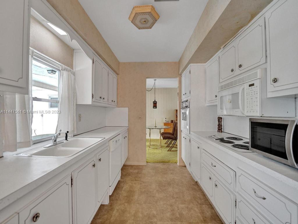 5525 Jackson Street Hollywood, FL 33021 - Photo 4 of 91 a large white kitchen with cabinets