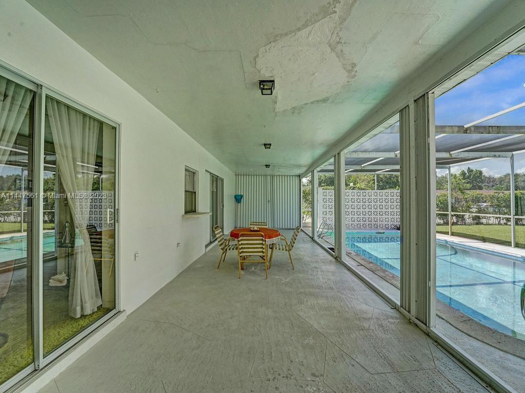 5525 Jackson Street Hollywood, FL 33021 - Photo 58 of 91 a view of a porch with furniture and floor to ceiling window