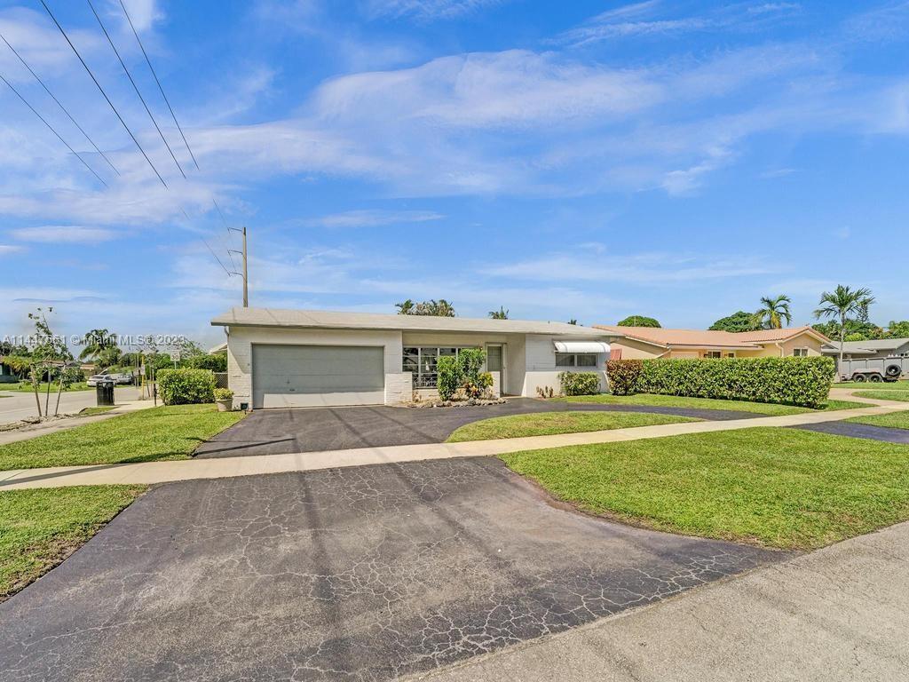 5525 Jackson Street Hollywood, FL 33021 - Photo 82 of 91 a front view of a house with a yard and garage
