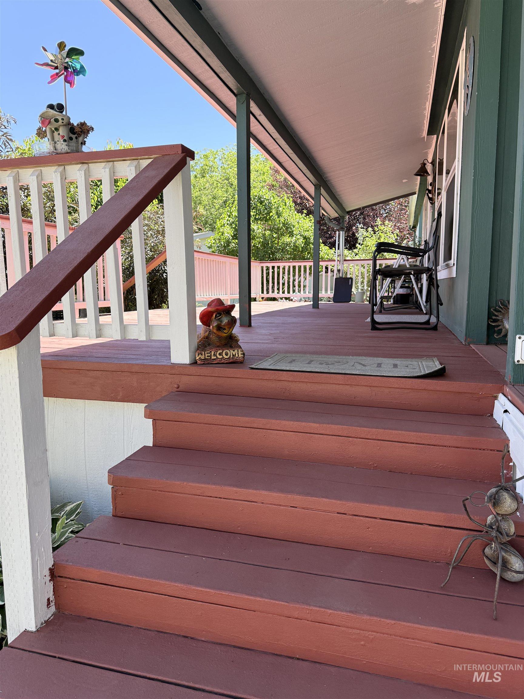 2750 Alden Road, Unit 12 12 Fruitland, ID 83619 - Photo 3 of 38 Expansive covered porch featuring wood-finish decking and steps, white railings, and exterior wall siding
