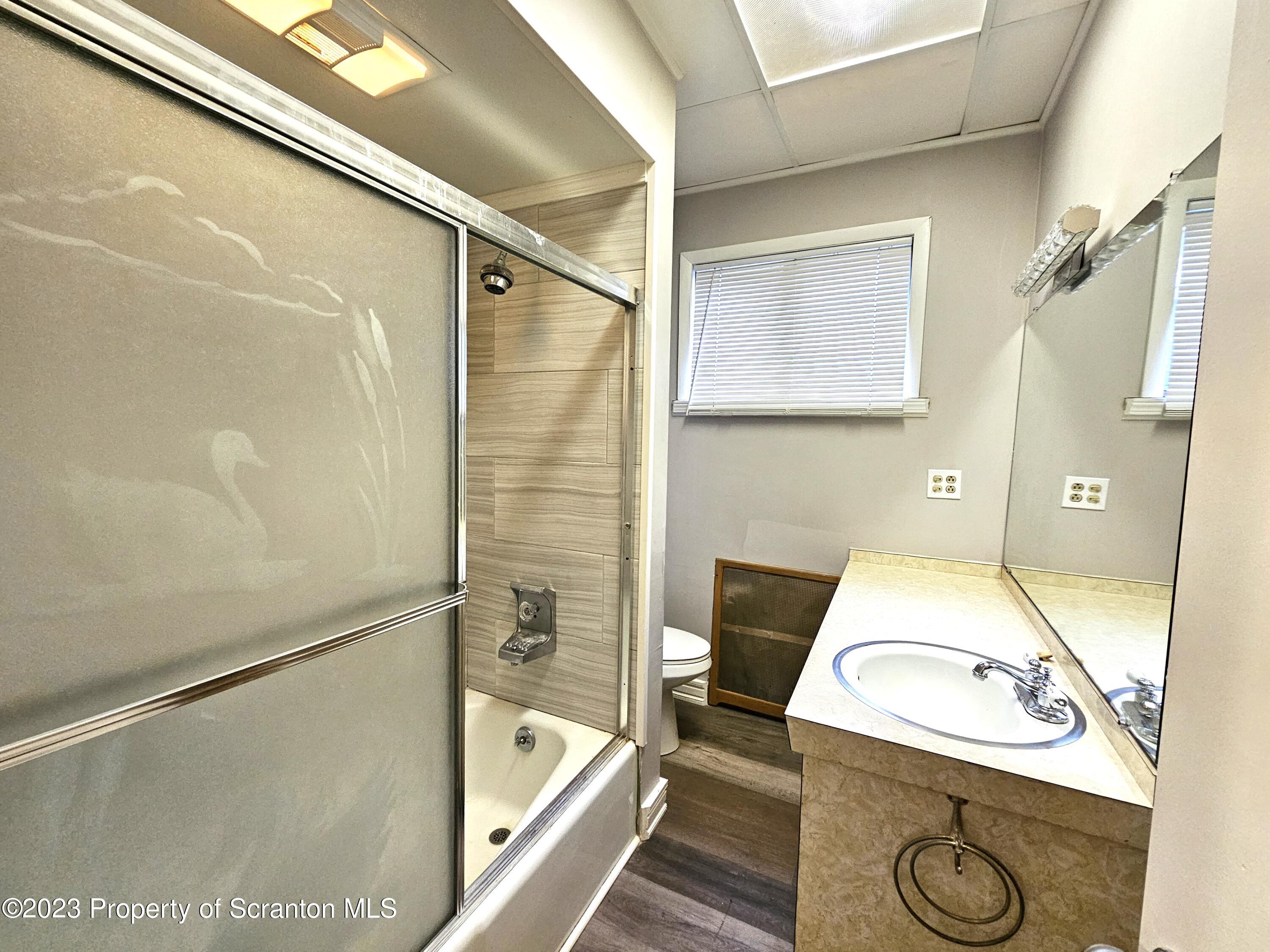 828 Cedar Avenue Scranton, PA 18505 - Photo 7 of 13 a bathroom with a sink a mirror and a shower