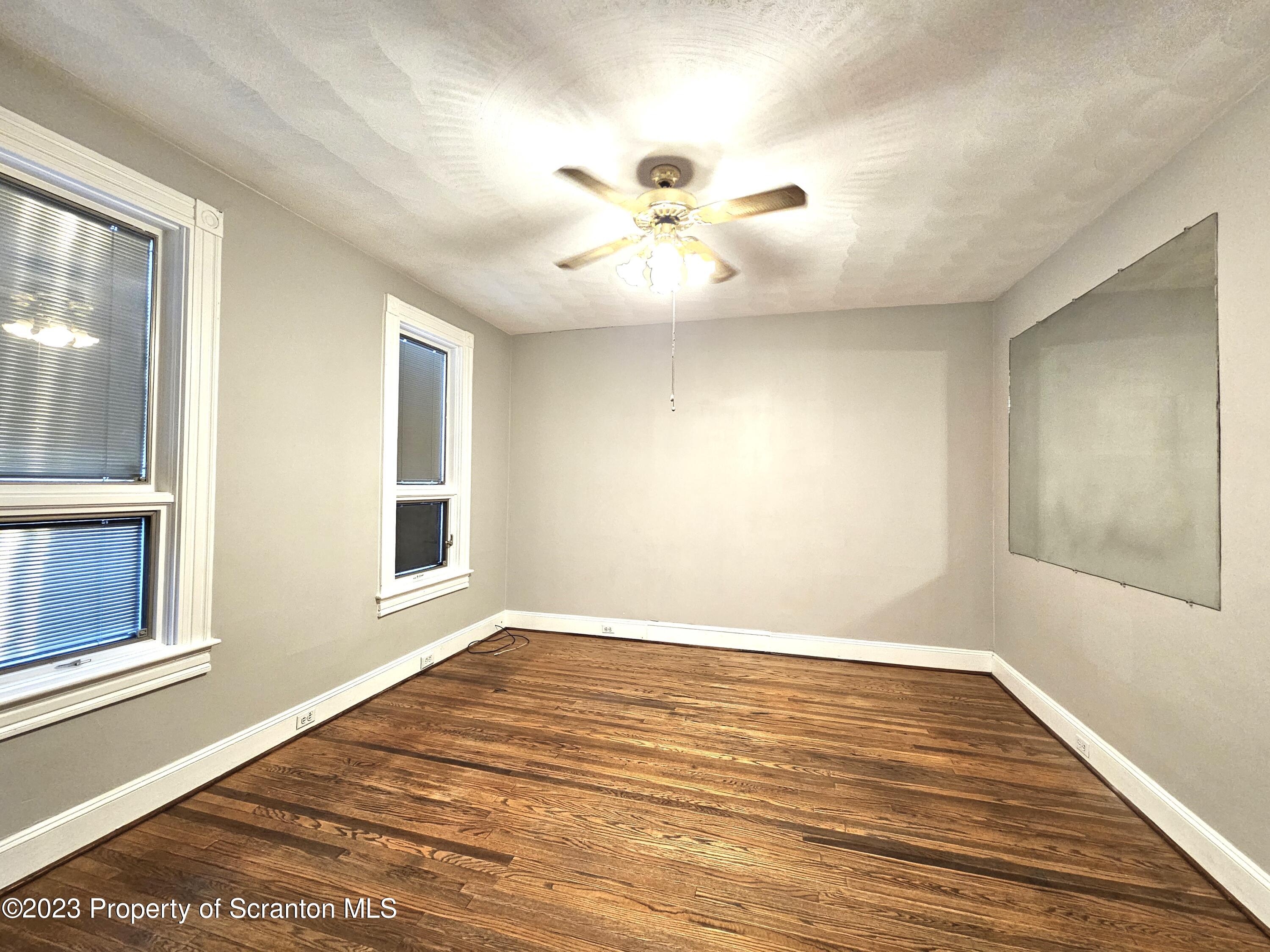828 Cedar Avenue Scranton, PA 18505 - Photo 9 of 13 a view of an empty room with wooden floor and a window