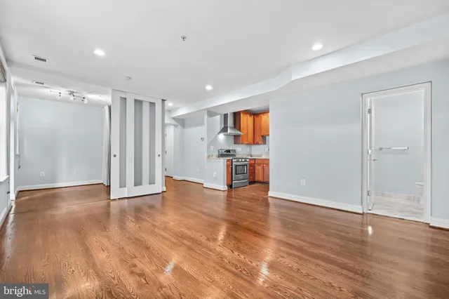 a view of empty room with wooden floor