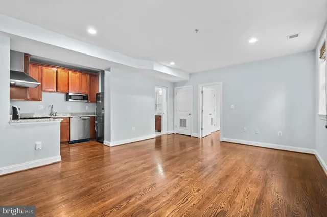 a view of a kitchen with a sink and wooden floor