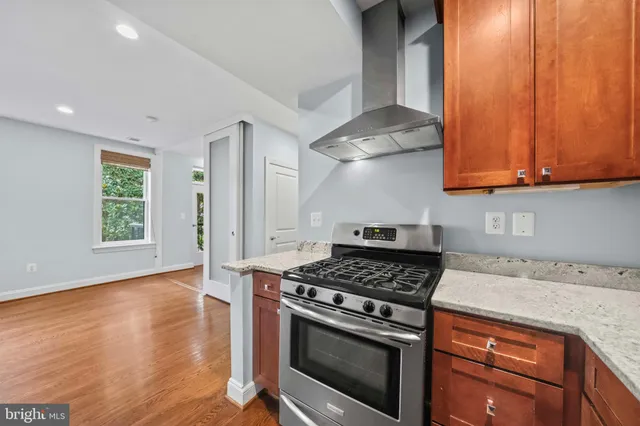 a kitchen with granite countertop wooden cabinets stainless steel appliances and a window