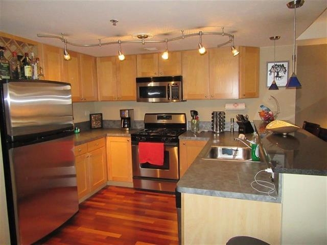 700 1st Street, Unit 12B Hoboken, NJ 07030 - Photo 3 of 10 a kitchen with granite countertop a stove top oven a sink a counter space and cabinets