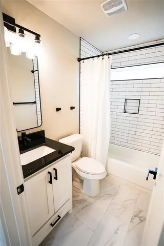 a bathroom with a granite countertop sink toilet and shower