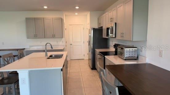 4520 Ranunculus Street Haines City, FL 33844 - Photo 5 of 19 a kitchen with stainless steel appliances a sink a stove a refrigerator a sink a counter top space and cabinets