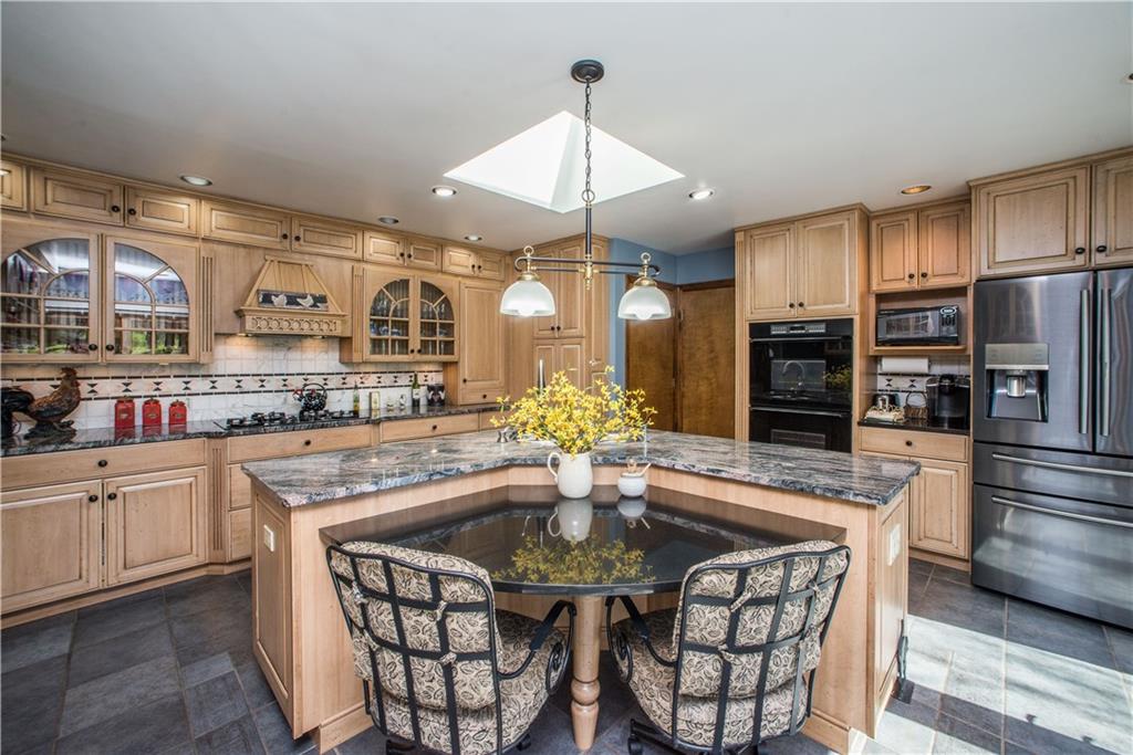 443 North Lewis Run Road West Mifflin, PA 15122 - Photo 11 of 25 One of the sprawling granite islands includes a breakfast nook where you can enjoy the natural light from the 3 French doors and the skylight.