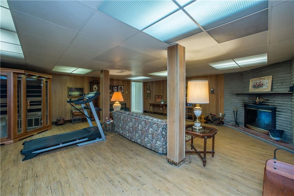 443 North Lewis Run Road West Mifflin, PA 15122 - Photo 21 of 25 The finished basement includes a large family room with a stone wood burning fireplace.