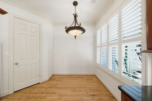 a view of a room with a chandelier fan and wooden floor