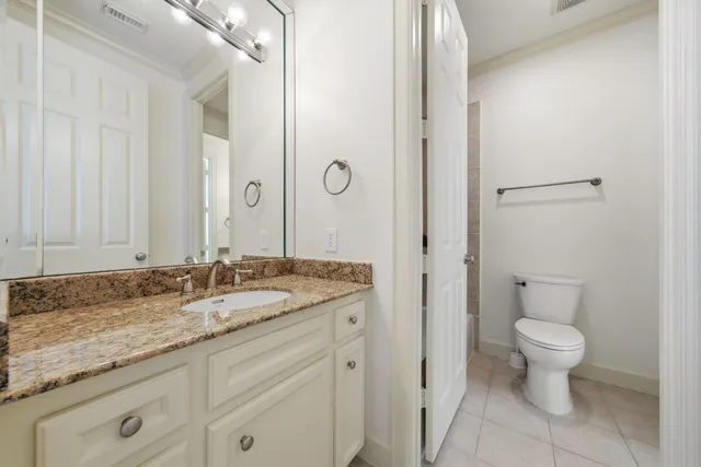 a bathroom with a granite countertop sink a toilet and a bathtub